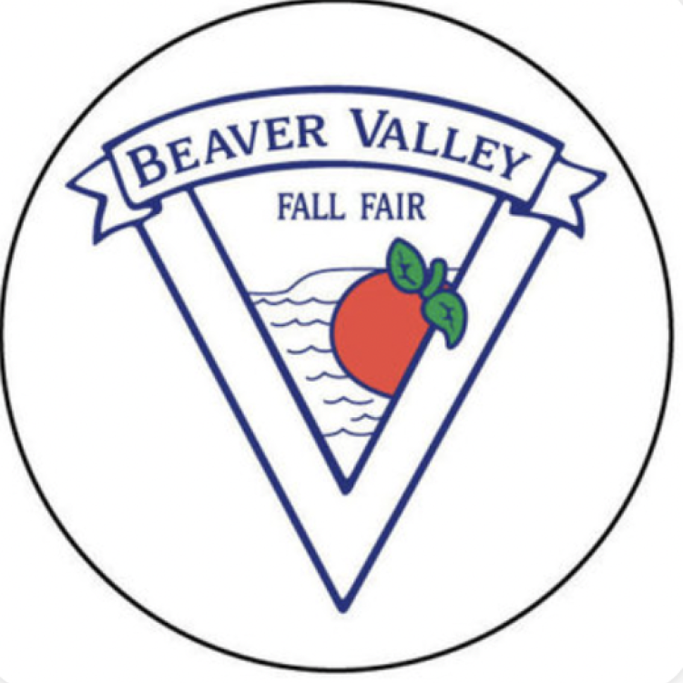 Black circle surrounding a triangle within a triangle logo with banner at top of the two triangles. The banner reads BEAVER VALLEY. Within the smaller triangle is written FALL FAIR, under the banner, and wave along shore The Blue Mountains with a red apple with green stem and leaves in front of the waves and shore. 