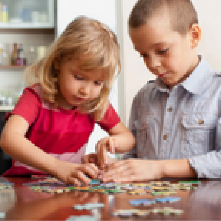 Two children completing a puzzle