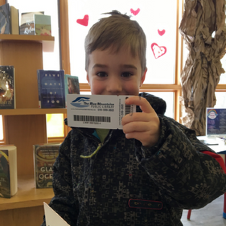 Boy shows his library card