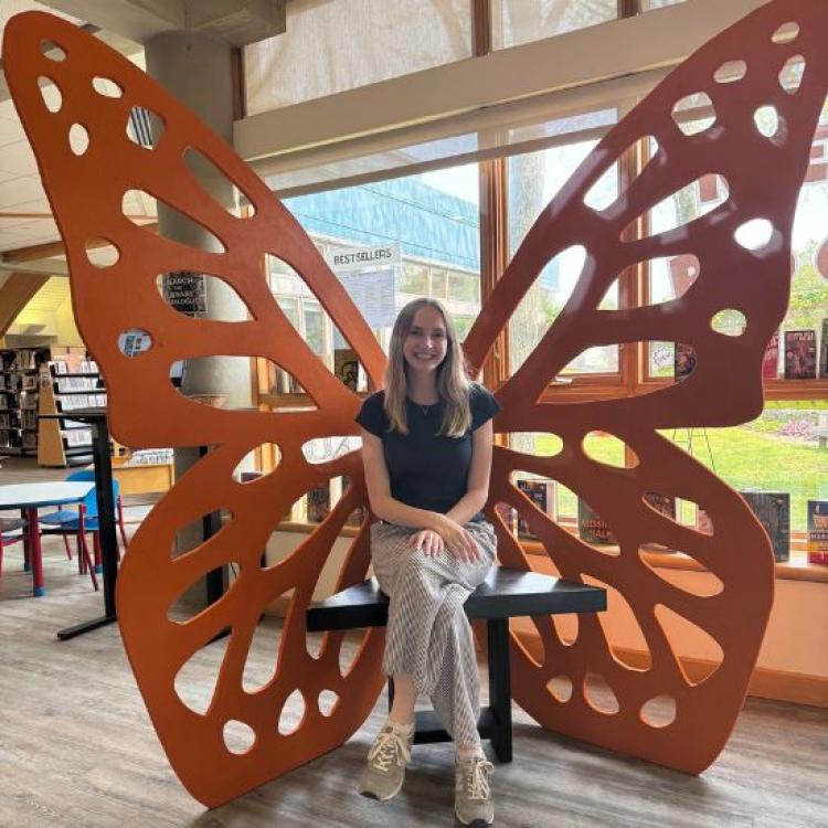 Teen sitting in butterfly photo op.