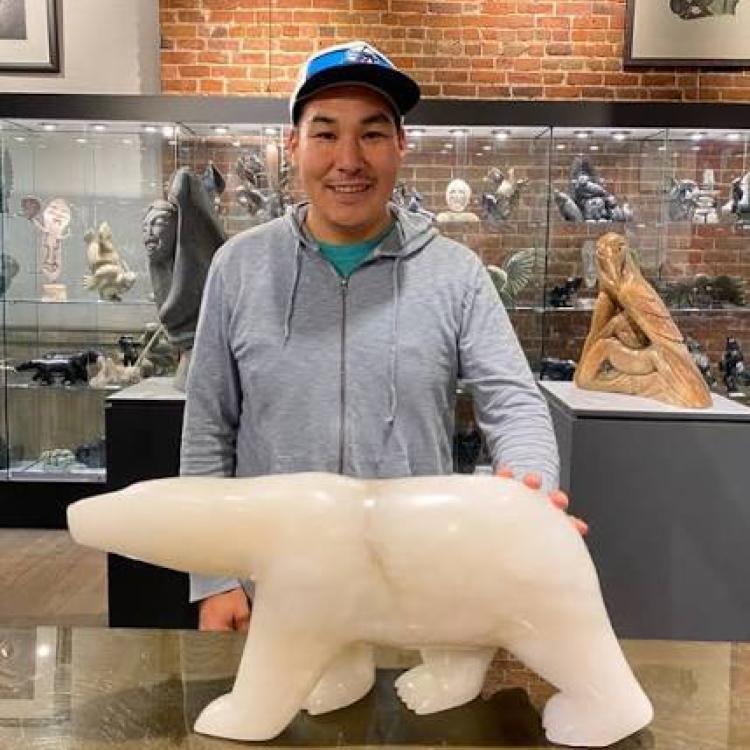 Inuit artist, Kuzy, with stone sculpture