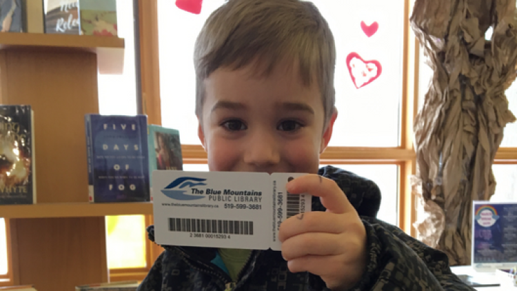 Happy kid showing off his new library card