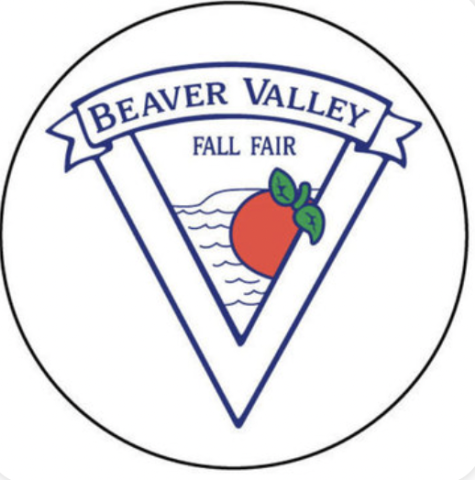 Black circle surrounding a triangle within a triangle logo with banner at top of the two triangles. The banner reads BEAVER VALLEY. Within the smaller triangle is written FALL FAIR, under the banner, and wave along shore The Blue Mountains with a red apple with green stem and leaves in front of the waves and shore. 