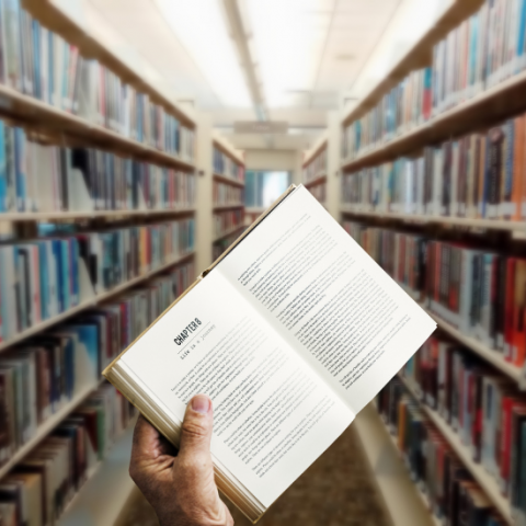 Library stacks with a book in the foreground