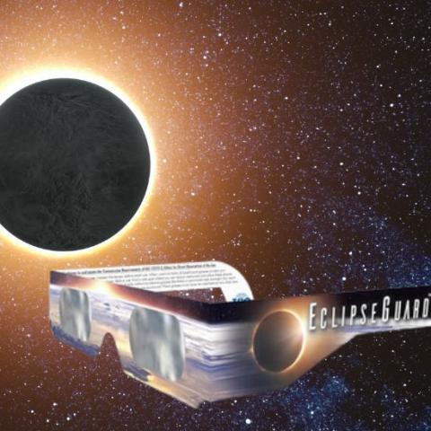 Solar eclipse glasses with an eclipse in the background
