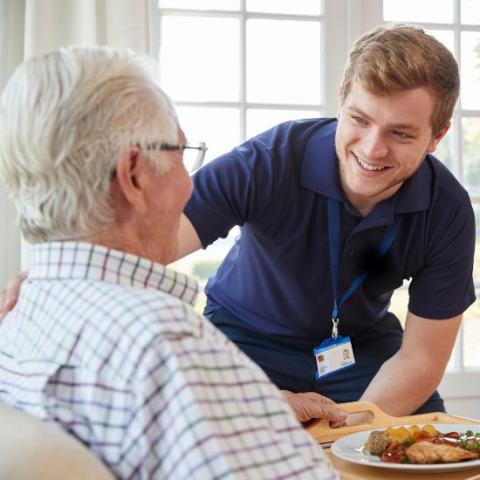 A nurse helping an older man in his home