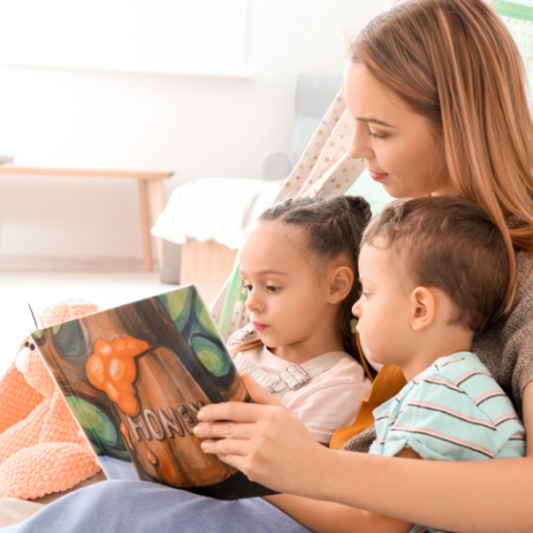 Woman sitting with two children reading a book together