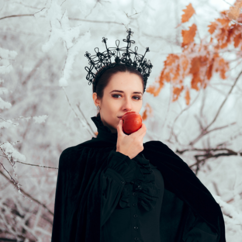 Evil queen dressed all in black eating a red apple