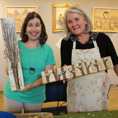 two friends holding up their art