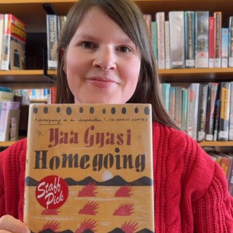 Emma holding a Homecoming by Yaa Gyasi
