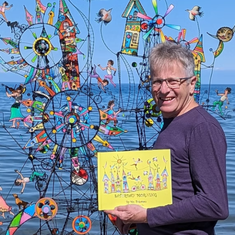 Artist James Paterson in front of large wire art installation