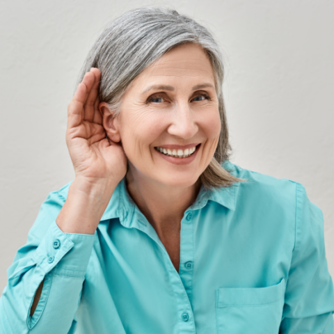 Woman holding her hand up to her ear