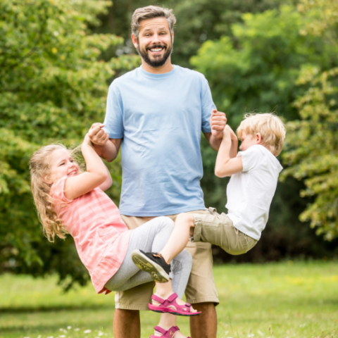 Father with two children swining from his arms
