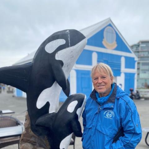Dr. George McMaster posing with whale statue