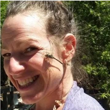 Jennifer Hammond smiling with a dragonfly on her cheek