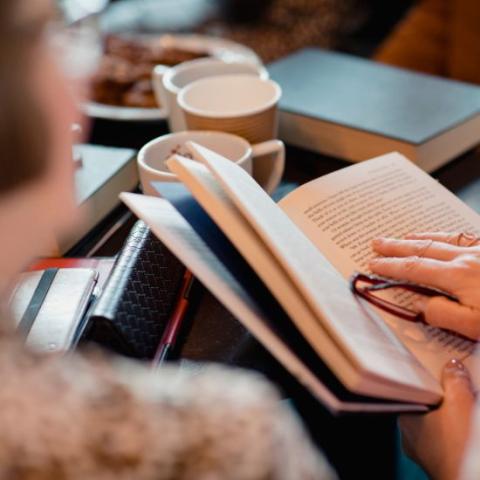 Group of people with books and mugs
