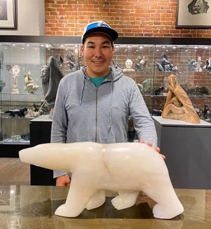 Inuit artist, Kuzy, with stone sculpture